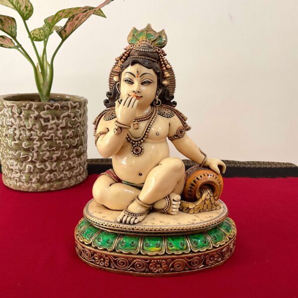 a statue of a baby sitting on a red surface